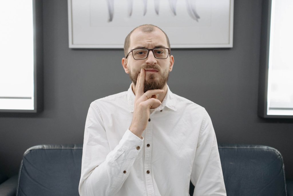 A balding man touching his face