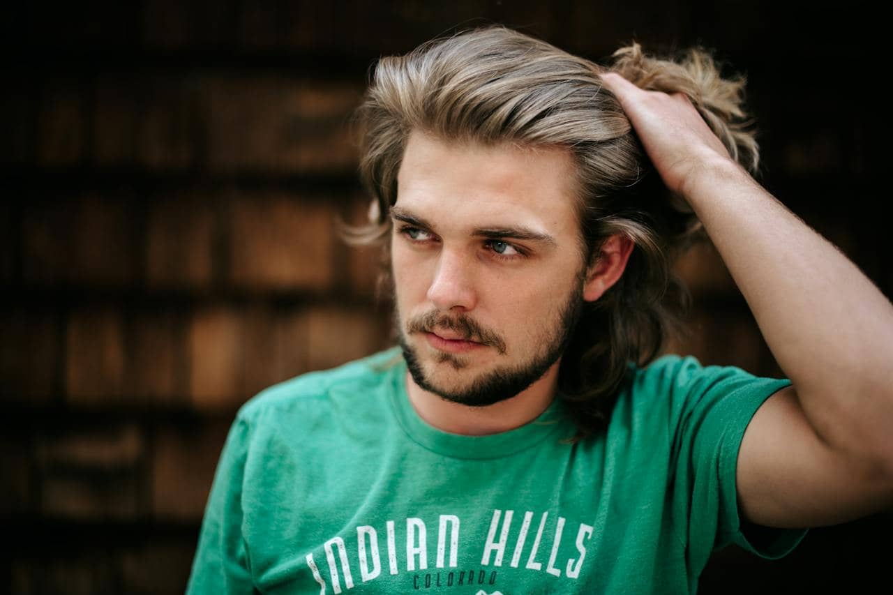 A Young Man Running His Hand Through His Hair