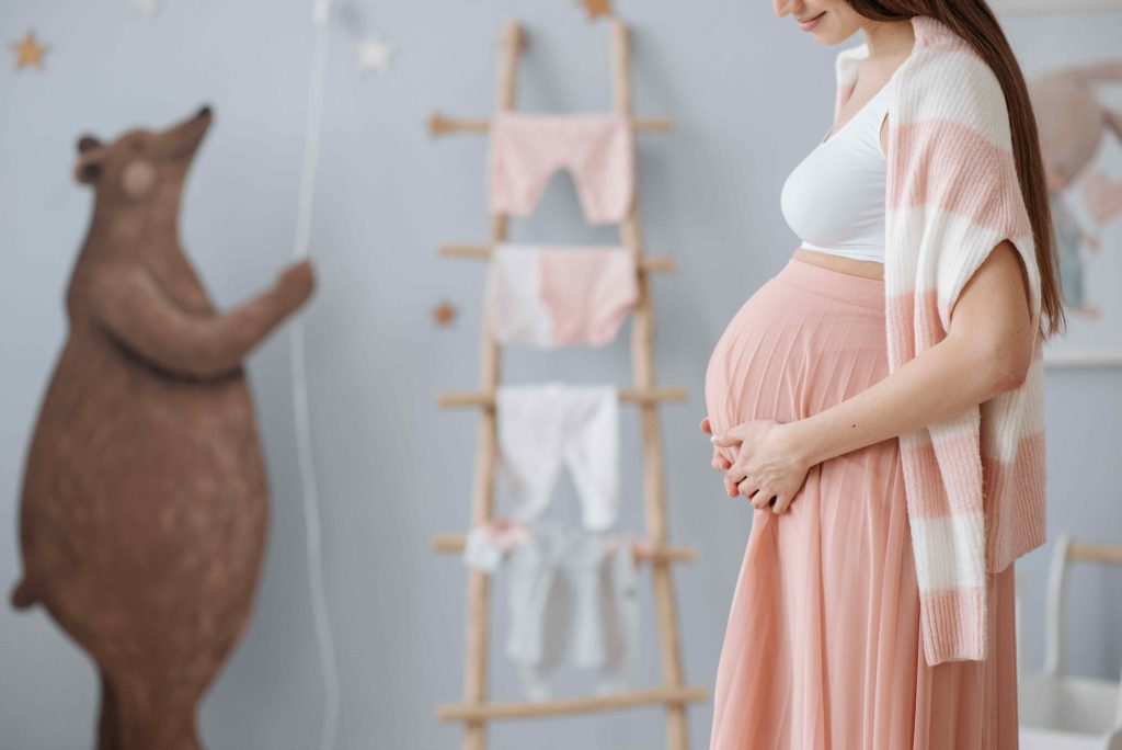 A pregnant woman holding her baby bump