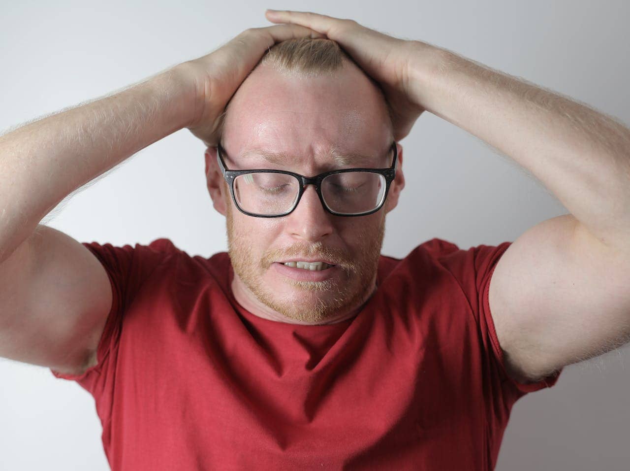 A Man Frustrated And Touching His Head