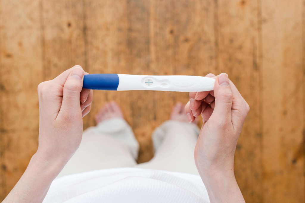 A woman holding a positive pregnancy test